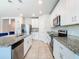 Modern kitchen with white cabinets, granite countertops, and stainless steel appliances at 3052 Cassidy Ln, Haines City, FL 33844