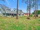 Home's back view, featuring a spacious yard and screened porch at 2226 Baker Ave, Orlando, FL 32833