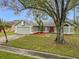 Single-story house with a green exterior and red door, nestled amongst trees at 2226 Baker Ave, Orlando, FL 32833