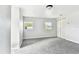 Large bedroom featuring new gray carpet, white walls and trim, and two sun-filled windows at 5431 9Th Se St, Lakeland, FL 33812