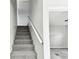 Carpeted stairs with a white railing leading to a living room with new gray carpet at 5431 9Th Se St, Lakeland, FL 33812