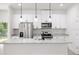 Modern kitchen with white cabinets, granite counters and island at 1305 Congo Ct, Poinciana, FL 34759