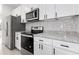 Modern kitchen with white cabinets, granite counters, and stainless appliances at 1305 Congo Ct, Poinciana, FL 34759