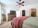 Bright bedroom featuring a dresser, ceiling fan, and a view into the living room at 1621 Saddlehorn Dr, Lakeland, FL 33810