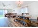 Open concept dining area with a wooden farmhouse table and bench, hardwood floors, and view into living room at 1621 Saddlehorn Dr, Lakeland, FL 33810
