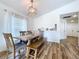 Bright dining room features a wooden table with bench seating, hardwood floors, and stylish light fixture at 1621 Saddlehorn Dr, Lakeland, FL 33810