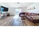 Living room with a brown leather sectional sofa, hardwood floors, and a large TV at 1621 Saddlehorn Dr, Lakeland, FL 33810
