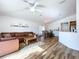 Open concept living room with hardwood floors, a leather sectional, and views to kitchen and dining area at 1621 Saddlehorn Dr, Lakeland, FL 33810