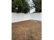 The backyard is enclosed with a tall white fence with a mix of bare dirt and patchy grass at 3709 Blarney Dr, Orlando, FL 32808