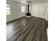 Bright living room with wood-look floors, a retro freestanding fireplace, and a ceiling fan at 3709 Blarney Dr, Orlando, FL 32808