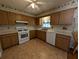 Kitchen with wood cabinets, white appliances, and tile flooring at 2150 Ne 54Th St, Ocala, FL 34479