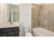 Bathroom featuring single sink vanity, large mirror and tiled shower and bathtub at 9076 Wildlight Trl, Wildwood, FL 34785