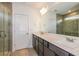 Bathroom featuring double sinks, a large mirror, and tiled walk-in shower at 9076 Wildlight Trl, Wildwood, FL 34785