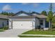 Charming single-Gathering home features a well-maintained lawn, a two-car garage, and craftsman-style architecture at 9076 Wildlight Trl, Wildwood, FL 34785
