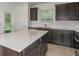 Bright kitchen features white countertops, dark wood cabinets, stainless steel appliances, and an exterior door at 9076 Wildlight Trl, Wildwood, FL 34785
