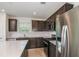 Well-equipped kitchen featuring stainless steel appliances, ample dark cabinetry, and a stylish subway tile backsplash at 9076 Wildlight Trl, Wildwood, FL 34785