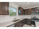Spacious kitchen featuring granite countertops, stainless steel appliances, and ample cabinet space with backyard views at 9076 Wildlight Trl, Wildwood, FL 34785