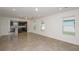Open living space with tiled floors, recessed lighting, connecting to a modern kitchen with backyard views at 9076 Wildlight Trl, Wildwood, FL 34785