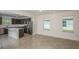 Open living space featuring tiled floors with kitchen and backyard views at 9076 Wildlight Trl, Wildwood, FL 34785