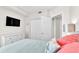 Bright bedroom with a TV, dresser, and double doors leading to the closet at 3737 S Atlantic Ave # 204, Daytona Beach Shores, FL 32118