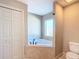 Bathroom with corner soaking tub, toilet and double doors at 16962 Sw 40Th Cir, Ocala, FL 34473