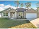 Tan house with white garage door, shutters, and landscaping at 16962 Sw 40Th Cir, Ocala, FL 34473