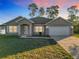Tan house with white garage door and landscaping at 16962 Sw 40Th Cir, Ocala, FL 34473