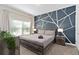 Spacious bedroom with a large bed and an accent wall at 8989 Cabot Cliffs Dr, Davenport, FL 33896
