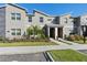 Modern two-story townhome with gray siding and a covered entryway at 8989 Cabot Cliffs Dr, Davenport, FL 33896
