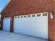 Two-car garage with white doors and brick exterior at 899 W Lake Marion Rd, Haines City, FL 33844