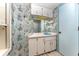 Bathroom featuring colorful wallpaper, white cabinets and a blue sink at 6141 Palmetto Dr, Indian Lake Estates, FL 33855