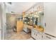 Bathroom featuring a large mirror, dual sinks and a shower area at 6141 Palmetto Dr, Indian Lake Estates, FL 33855