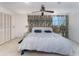 Well-lit bedroom with a ceiling fan, spacious closet, and large bed at 6141 Palmetto Dr, Indian Lake Estates, FL 33855