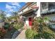 Inviting front entrance with red door, lush landscaping and stone path at 6141 Palmetto Dr, Indian Lake Estates, FL 33855