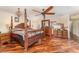 Spacious main bedroom featuring hardwood floors, ceiling fan and an elegant chandelier at 6141 Palmetto Dr, Indian Lake Estates, FL 33855