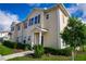 Tan three-story townhome with landscaping and walkway at 3231 Cupid Pl Pl, Kissimmee, FL 34747