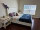 Comfortable bedroom featuring hardwood floors, a bed, and a bright window for natural light at 525 Waterside Pointe Dr, Groveland, FL 34736