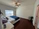 Inviting bedroom features hardwood floors, comfortable bed, and natural light from a bright window at 525 Waterside Pointe Dr, Groveland, FL 34736