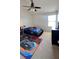 A bedroom featuring a race car bed, ceiling fan, and neutral carpet. The window allows for plenty of natural light at 525 Waterside Pointe Dr, Groveland, FL 34736