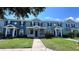 Charming townhome with a manicured front lawn and inviting entrance, complete with classic architectural details and an American flag at 525 Waterside Pointe Dr, Groveland, FL 34736