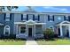 Charming townhome with a manicured front lawn and inviting entrance, complete with classic architectural details and an American flag at 525 Waterside Pointe Dr, Groveland, FL 34736
