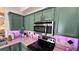 Stylish kitchen boasting green cabinetry, stainless steel appliances, and granite countertops at 525 Waterside Pointe Dr, Groveland, FL 34736