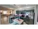 Bright, open kitchen with stainless appliances, green cabinets, a kitchen island and view to a living room at 525 Waterside Pointe Dr, Groveland, FL 34736