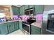 Stylish kitchen boasting green cabinetry, stainless steel appliances, and granite countertops at 525 Waterside Pointe Dr, Groveland, FL 34736