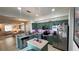 Spacious kitchen and living area features stainless steel appliances, green cabinets, and a kitchen island at 525 Waterside Pointe Dr, Groveland, FL 34736