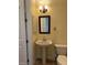 Small bathroom with pedestal sink, toilet and a small medicine cabinet at 2300 Se 73Rd Loop, Ocala, FL 34480