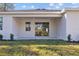 Covered back patio with sliding glass doors, leading to a grassy backyard at 5830 Sw 121 St, Ocala, FL 34481