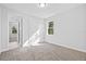 Bright bedroom with double doors leading to a bathroom and large window at 5830 Sw 121 St, Ocala, FL 34481