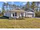 House exterior showcasing a landscaped lawn and attached garage at 5830 Sw 121 St, Ocala, FL 34481