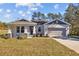 One-story home with gray siding, stone accents, and a two-car garage at 5830 Sw 121 St, Ocala, FL 34481
